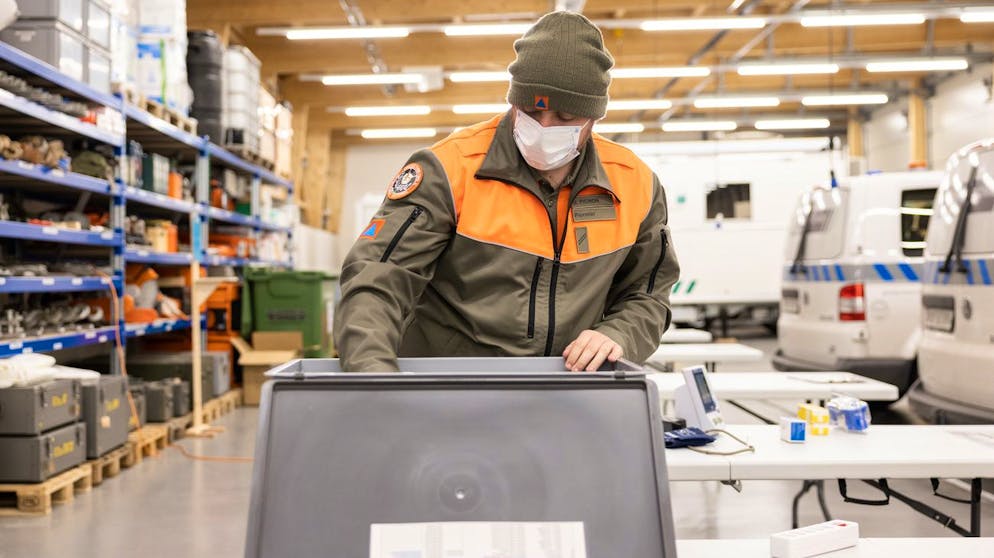Un membre d'une equipe mobile de vaccination de la protection civile vaudoise, PC, prepare le materiel pour la vaccination au centre de competence de la protection civil de Gollion pendant la pandemie de Coronavirus (Covid-19), ce vendredi, 22 janvier 2021 a Gollion. (KEYSTONE/Cyril Zingaro)