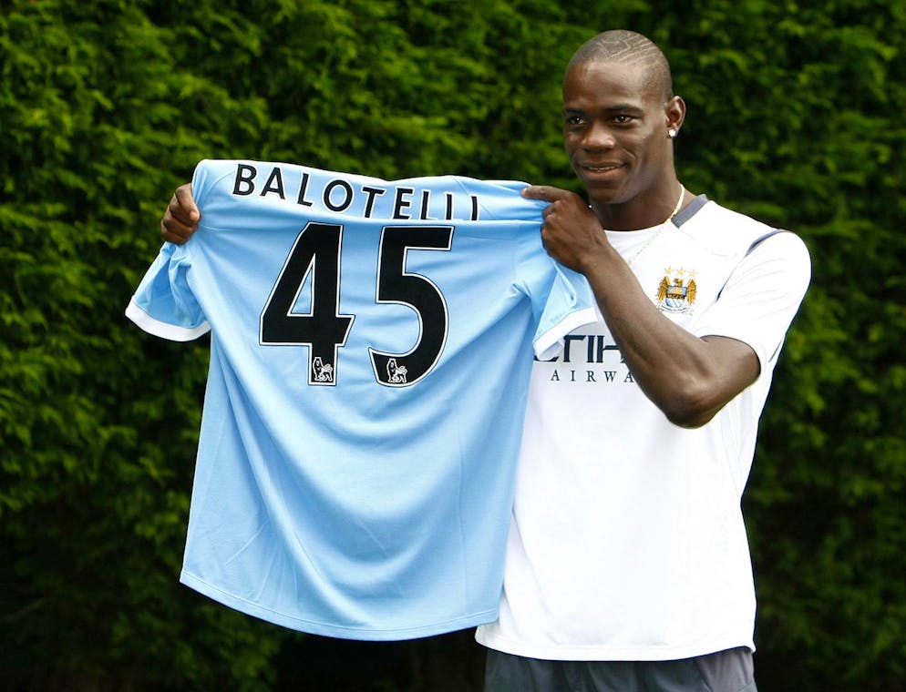 Manchester City's new signing Mario Balotelli holds up his shirt after a press conference held at the Carrington training ground, Manchester, England, Tuesday Aug. 17, 2010. Balotelli was signed from Inter Milan. (AP Photo/Tim Hales)
