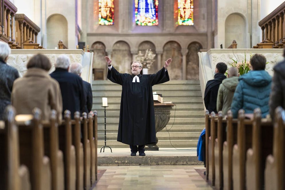 Pfarrer Christoph Sigrist haelt vor 50 Personen den Gottesdienst am Sonntag, 24. Januar 2021, im Zuercher Grossmuenster. Aufgrund der aktuellen Corona-Beschraenkungen ist die Anzahl der Besucher auf 50 Personen beschraenkt. (KEYSTONE/Gaetan Bally)