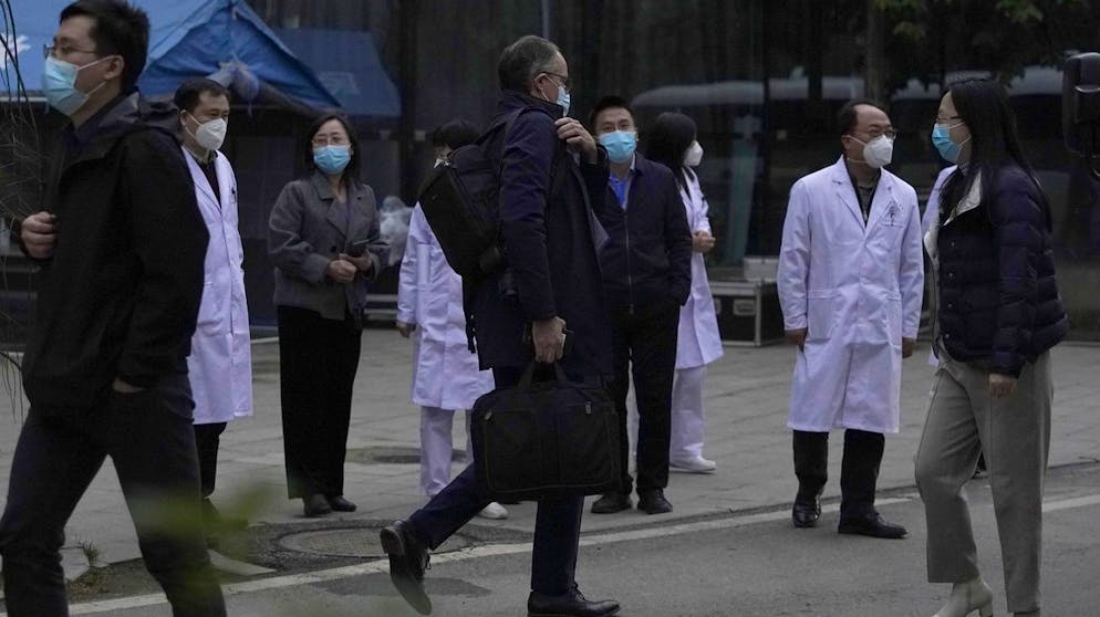 Peter Ben Embarek of the World Health Organization team, center, passes by Chinese doctors during a visit to the Hubei Provincial Hospital of Integrated Chinese and Western Medicine also know as the Hubei Province Xinhua Hospital in Wuhan in central China's Hubei province on Friday, Jan. 29, 2021. The World Health Organization team on Friday visited the hospital where China says the first COVID-19 patients were treated more than a year ago as part of the experts' long-awaited fact-finding mission on the origins of the coronavirus. (AP Photo/Ng Han Guan)