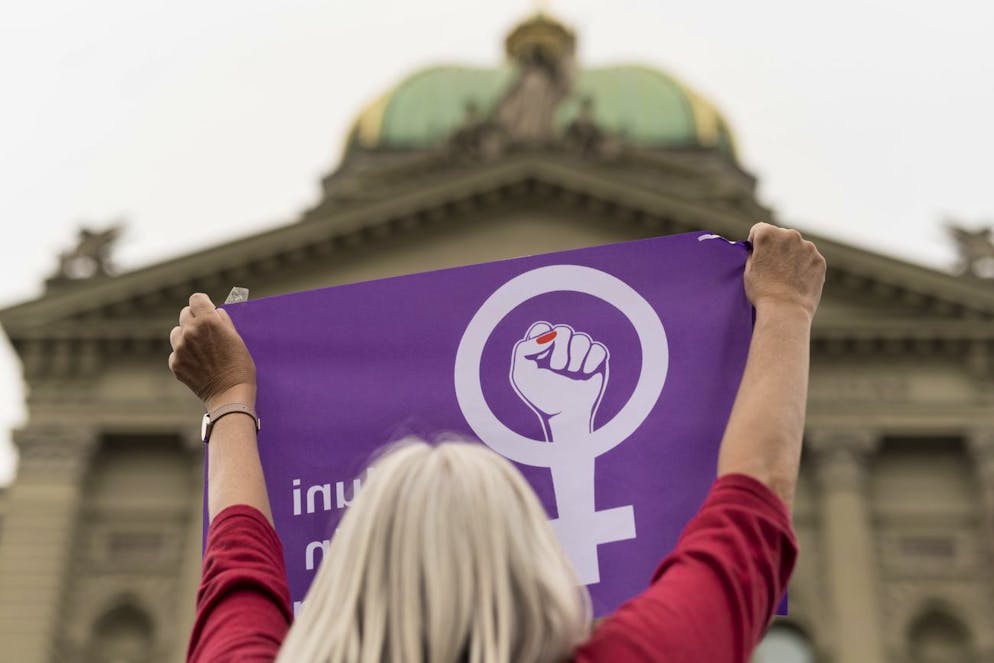 Eine Frau schwingt die Fahne des Frauenstreiks vor dem Bundeshaus, am Freitag, 14. Juni 2019 in Bern. (KEYSTONE/Alessandro della Valle)