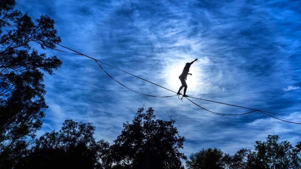 Bilder des Tages. Vor einem pittoresken Wolkenhimmel zeigt Max Ross auf einer Slackline im Hillcrest Park im kalifornischen Fullerton sein Können. (30.1.2021)