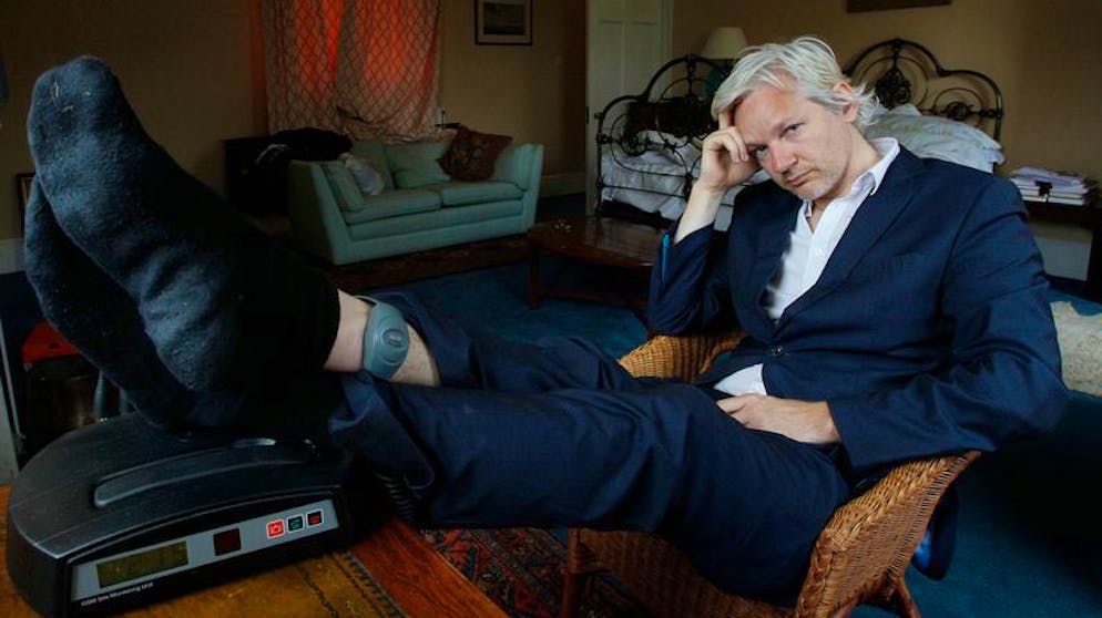 ARCHIV - 15.06.2011, Großbritannien, Bungay: WikiLeaks-Gründer Julian Assange sitzt mit einer elektronischen Fußfessel an einem Schreibtisch. Am 04.01.2021 verkündet das Gericht das Urteil im US-Auslieferungsantrag gegen Assange. Foto: Kirsty Wigglesworth/AP/dpa +++ dpa-Bildfunk +++