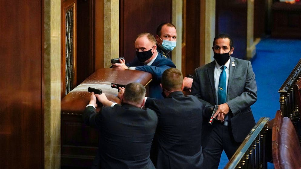 Gewalt in Washington: Trumps Mob stürmt das Kapitol. Mitglieder der Capitol Police bewachen mit gezogener Waffe einen verbarrikadierten Eingang. (6. Januar 2021)