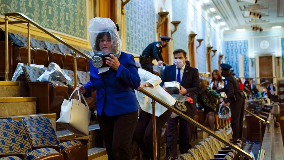 Gewalt in Washington: Trumps Mob stürmt das Kapitol. Abgeordnete werden von Sicherheitskräften auf der Tribüne des Repräsentantenhauses in Sicherheit gebracht. Einige tragen Gasmasken, da auch Reizgas eingesetzt wird. (6. Januar 2021)