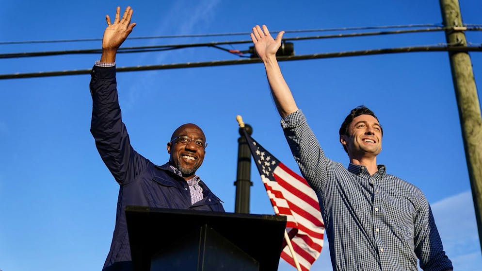 FILE - In this Nov. 15, 2020, file photo Georgia Democratic candidates for U.S. Senate Raphael Warnock, left, and Jon Ossoff, right, gesture toward a crowd during a campaign rally in Marietta, Ga. (AP Photo/Brynn Anderson, File)