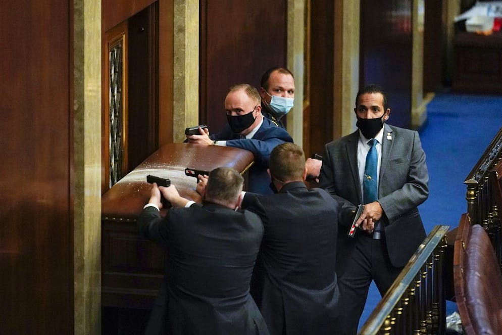 Irruzione dei fan di Trump a Capitol Hill. La polizia di Capitol Hill con le pistole in mano per cercare di difendere la sala dall'assalto dei sostenitori di Trump.