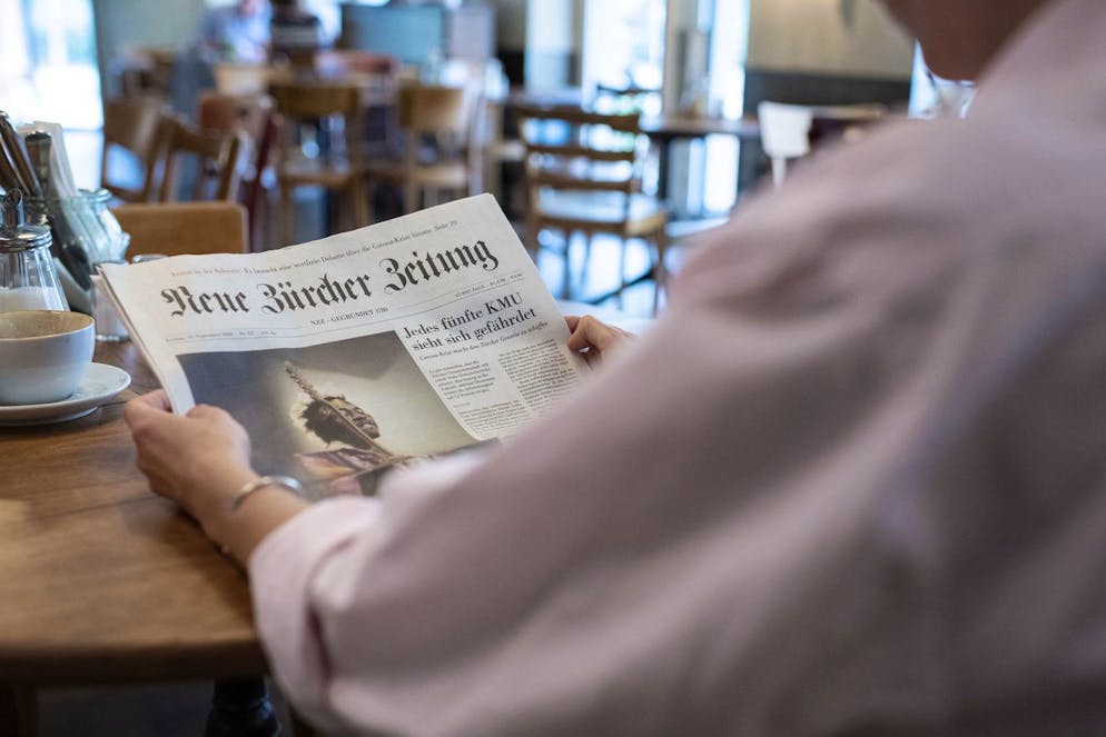Eine Frau liest in einem Cafe die Neuen Zuercher Zeitung, fotografiert am 18. September 2020 in Zuerich. (KEYSTONE/Christian Beutler)
