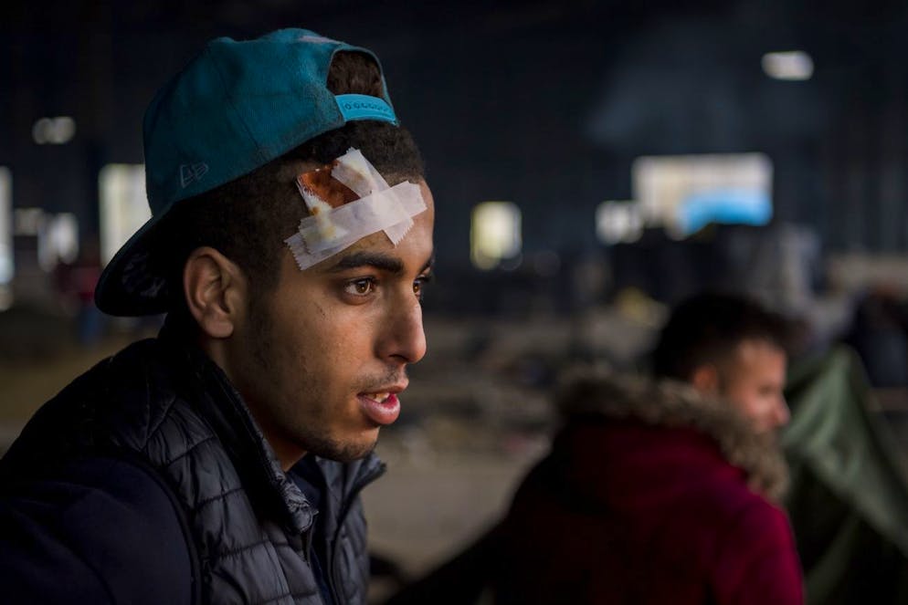 A migrant reacts as he receives medical assistance from the Red Cross in a illegal refugee camp inside a abadoned factory in Velika Kladusa near Bihac, alongside the border with Croatia, western Bosnia and Herzegovina, Monday, December 2, 2019. (KEYSTONE/Jean-Christophe Bott)