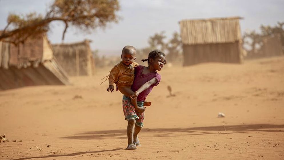 ARCHIV - 11.06.2021, Madagaskar, Amboasary District: Kinder im Süden Madagaskars. Die schlimmste Dürre seit 40 Jahren gefährdet in dem vor Afrikas Ostküste gelegenen Inselstaat Madagaskar das Leben hunderttausender Menschen. Betroffen seien vor allem aber auch die Kinder, warnte die Hilfsorganisation Save the Children. Zehntausende stehen in Madagaskar kurz vor dem Hungertod. Seit vier Jahren herrscht Dürre. Es gibt kein sauberes Trinkwasser, nichts zu Essen. Und Regen ist nicht in Sicht. (zu dpa: «Hungersnot in Madagaskar: Menschen essen Lehm und Blätter») Foto: Tsiory Andriantsoarana/WFP/dpa - ACHTUNG: Nur zur redaktionellen Verwendung und nur mit vollständiger Nennung des vorstehenden Credits. Das Foto darf nicht verändert werden! +++ dpa-Bildfunk +++