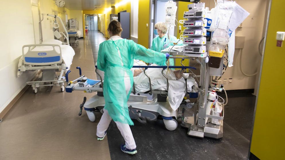 Medical worker pushes a patient into a hospital bed in the emergency room unit at the University Hospital (CHUV) during the state of emergency of the coronavirus disease (COVID-19) outbreak, in Lausanne, Switzerland, Tuesday, March 31, 2020. Countries around the world are taking increased measures to stem the widespread of the SARS-CoV-2 coronavirus which causes the Covid-19 disease. (KEYSTONE/POOL/Laurent Gillieron)