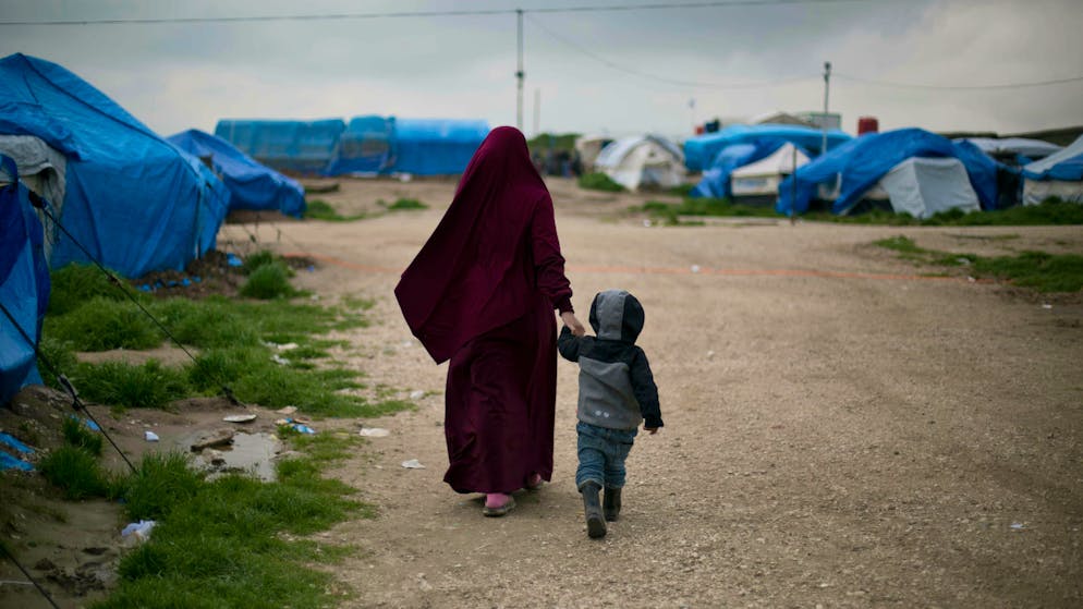 In this March 27, 2019, photo, Samira from Belgium walks with her son at Camp Roj in north Syria. She traveled to Syria, where Islamic State militants brought suitors for marriage. Samira chose a French citizen, Karam El-Harchaoui. Her husband now imprisoned for IS ties, she is trying to get home to Belgium. “What we saw with Daesh was a lesson to us and allowed us to gain perspective on the extremists. All we want is to reintegrate in our society,” she said, using an Arabic acronym for IS. (AP Photo/Maya Alleruzzo)