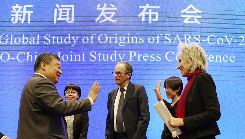 Marion Koopmans, right, and Peter Ben Embarek, center, of the World Health Organization team say farewell to their Chinese counterpart Liang Wannian, left, after a WHO-China Joint Study Press Conference held at the end of the WHO mission in Wuhan, China, Tuesday, Feb. 9, 2021. (AP Photo/Ng Han Guan)