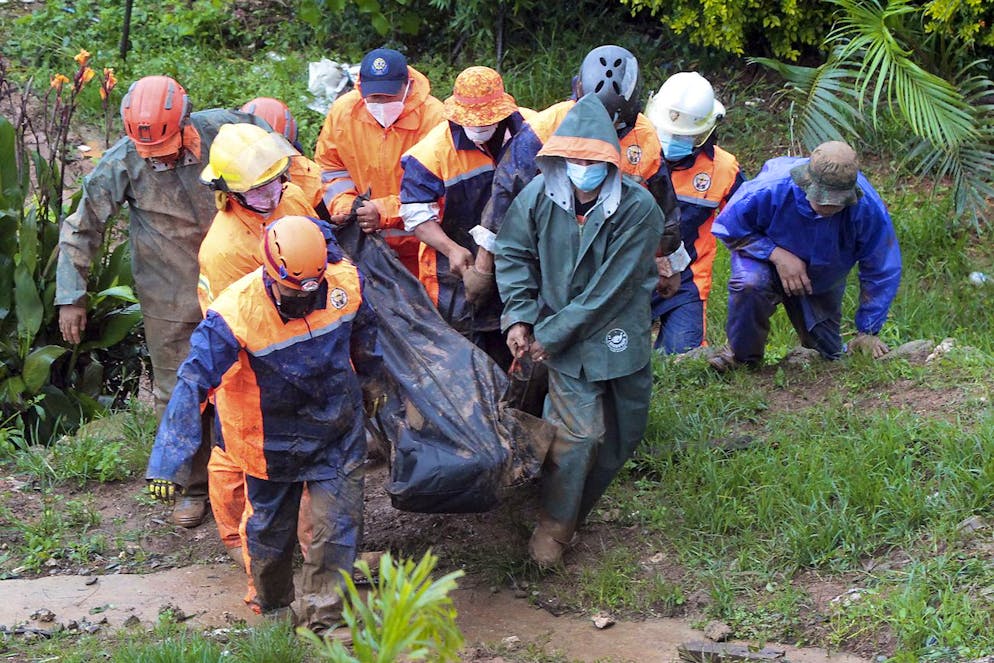 Rescuers carry the body of a victim caught in a landslide caused by Tropical Storm Kompasu in Baguio city, northern Philippines on Tuesday Oct. 12, 2021. A number of people have been killed and others were reported missing in landslides and flash flood set off by a storm that barreled through the tip of the northern Philippines overnight then blew away Tuesday, officials said. (AP Photo)