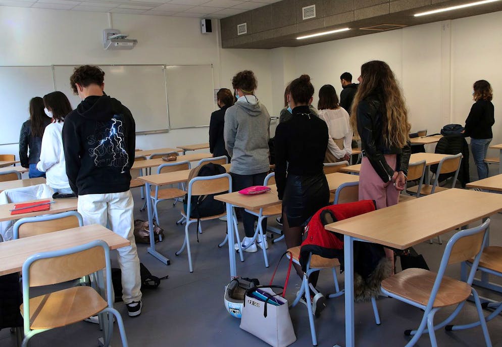 Students of Rene Cassin high school observe a minute of silence for slain history teacher Samuel Paty in Bayonne, southwestern France, Friday, Oct. 15, 2021. French schools are paying tribute to a teacher beheaded by a radical Islamist last year after he showed caricatures of the prophet of Islam to his class. Samuel Paty, a history and geography teacher, was murdered on Oct. 16 last year near his school in a northwest Paris suburb by an 18-year-old of Chechen origin who had become radicalized. (AP Photo/Bob Edme)