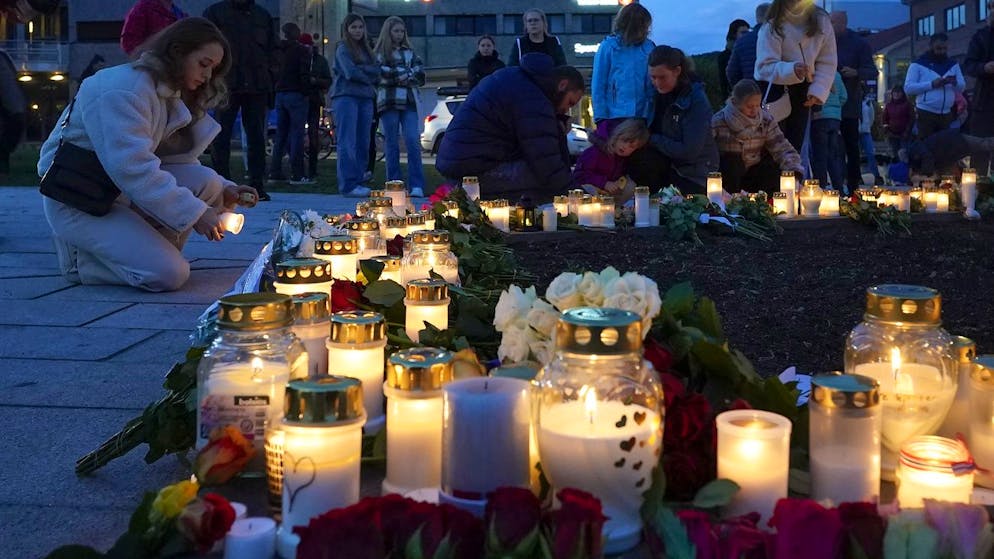 Flowers and candles are placed at the scene of an attack on the square, in Kongsberg, Norway, Thursday, Oct. 14, 2021. Norwegian authorities say the bow-and-arrow rampage by a man who killed five people in a small town appeared to be a terrorist act. Police identified the attacker as Espen Andersen Braathen, a 37-year-old Danish citizen, who was arrested Wednesday night. (Terje Bendiksby/NTB via AP)