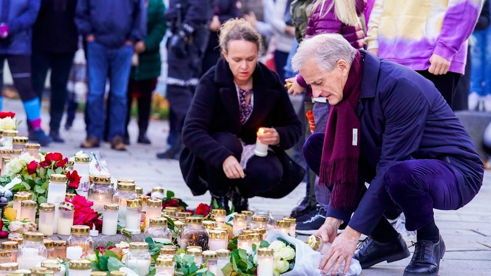 Jonas Gahr Støre (r), Ministerpräsident von Norwegen, legt bei seinem Besuch in Kongsberg Blumen für die Opfer eines Attentats nieder.