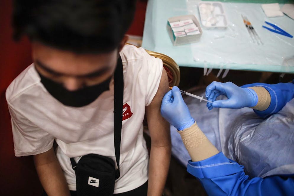 epa09508959 A teenager (L) receives a dose of Pfizer COVID-19 vaccine during a vaccination program for teenagers under 18-year-old in Shah Alam, outside Kuala Lumpur, Malaysia, 06 October 2021. The Malaysian government is targeting at least 60 percent of the country's teenager population to receive at least one dose of vaccine by November this year, with the aim of having 80 percent of teenagers fully vaccinated by next January. EPA/FAZRY ISMAIL