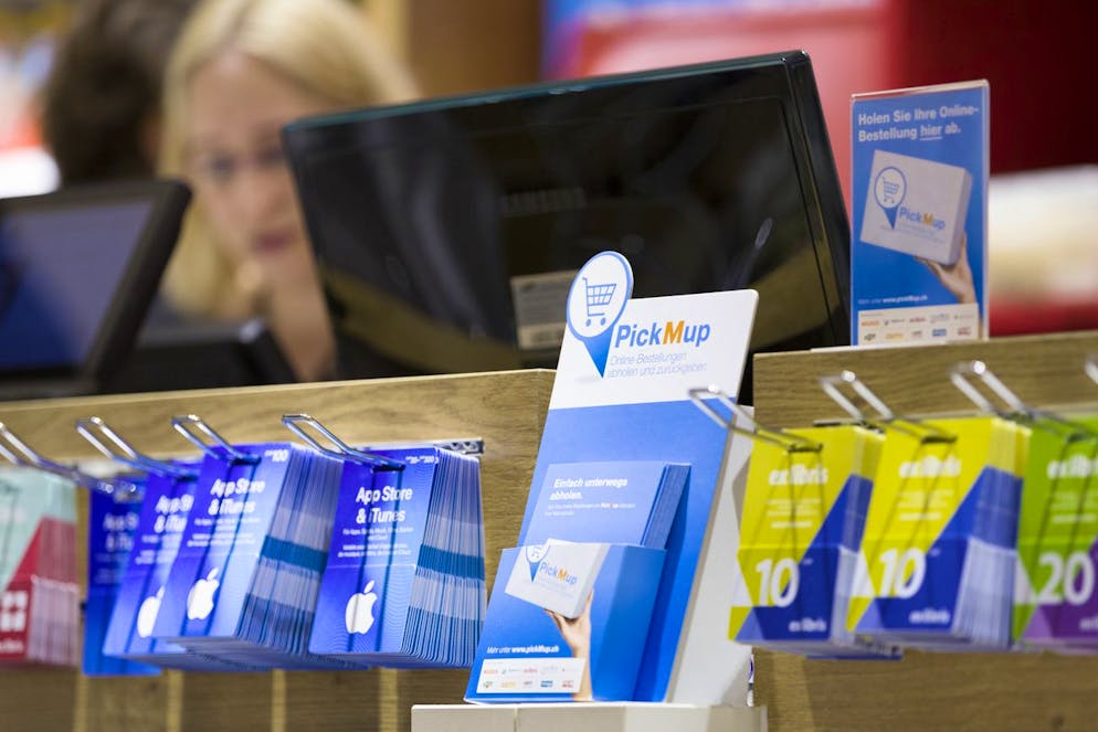 Des dépliants d'information sur le service de retrait PickMup informent sur la possibilité de retirer des achats en ligne à la caisse du magasin.