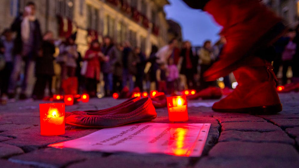 Des bougies sont placees vers des chaussure rouge et des pancarte denoncant des violences sur les femmes, ce vendredi, 25 novembre 2016, sur la place Palud a Lausanne. Lors d'un rassemblement en hommage aux victimes des feminicides en Suisse et de toutes les femmes victimes et survivantes des violences masculines organise par Feminista, dans le cadre de la journee internationale pour l'elimination des violences envers les femmes. (KEYSTONE/Leo Duperrex)