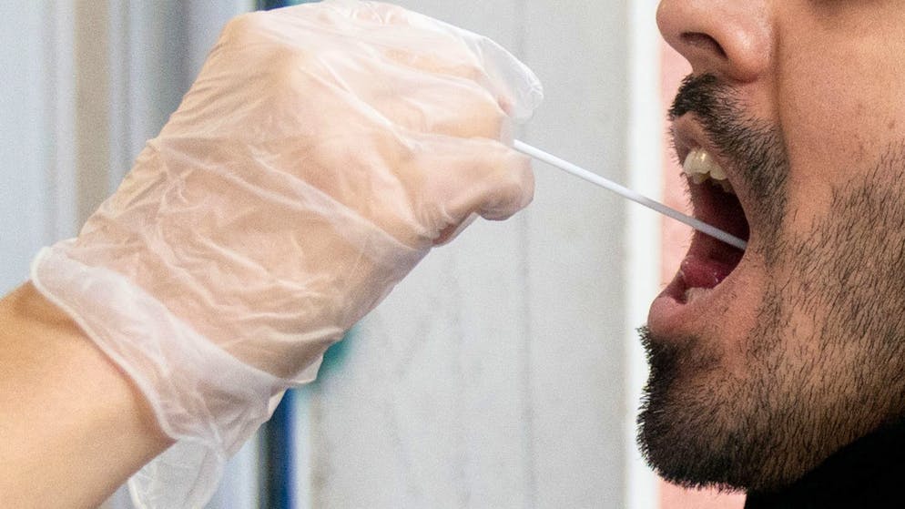 Ein Patient lässt vor einer Arztpraxis einen Abstrich für einen PCR Corona-Test machen. (Archivbild)