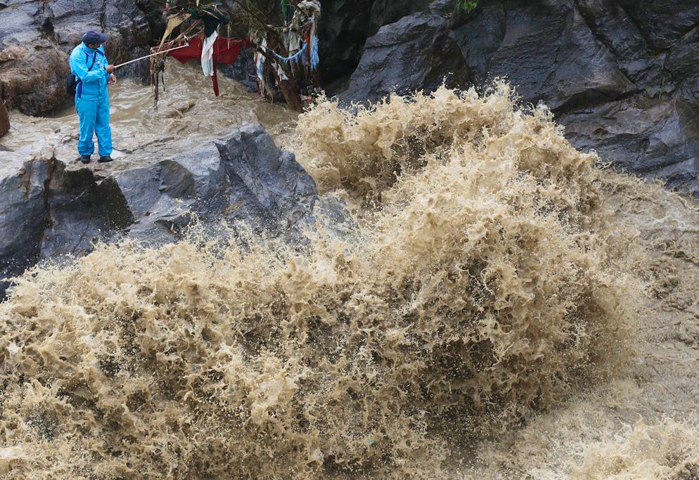 A Nepalese man takes selfie on the banks of flooded Bagmati river in Kathmandu, Nepal, Tuesday, July 21, 2020. Landslides and flooding caused by continuous heavy rainfall has blocked the main highway that connects Nepal's capital to most of the Himalayan nation blocking trucks bringing fuel and supplies, officials said Tuesday. (AP Photo/Niranjan Shrestha)