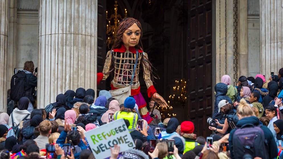 epa09540773 'Little Amal,' a 3.5-meter-tall puppet representing a young Syrian refugee girl visits St Paul's Cathedral in London, Britain, 23 October 2021. Amal arrived in Britain on 19 October 2021 on the last leg of an 8,000-kilometre journey to raise awareness about the plight of young refugees. The puppet created by the Handspring company travelled from Syria to Turkey, Greece, Italy, France, Switzerland, Germany, Belgium, and Britain as part of the art initiative 'The Walk. EPA/VICKIE FLORES
