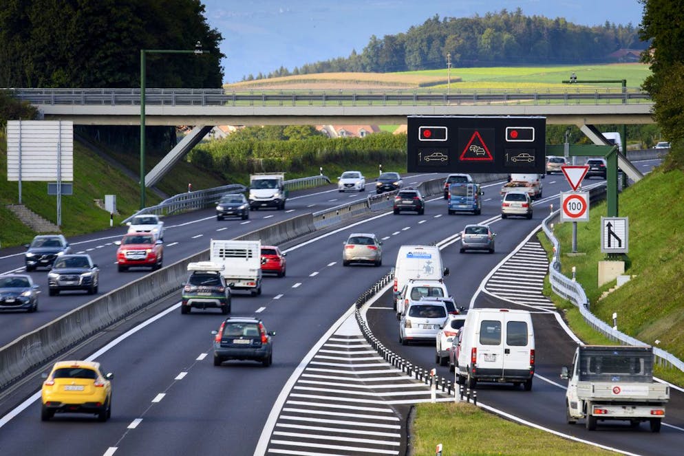 Des voitures attendent a un feu rouge sur la rampe de dosage alors que des voitures circulent sur sur l' autoroute Yverdon - Lausanne, A1, au droit de la jonction autoroutiere de Cossonay sur la chaussée Alpes ce mardi 28 septembre 2021 a Sullens. C'est une première sur une autoroute de Suisse romande: il faudra patienter a un feu rouge avant d'entrer sur l'autoroute A1 entre Lausanne et Yverdon a la hauteur de Cossonay (VD). Ce systeme de dosage doit permettre de fluidifier le trafic aux heures de pointe. (KEYSTONE/Laurent Gillieron)
