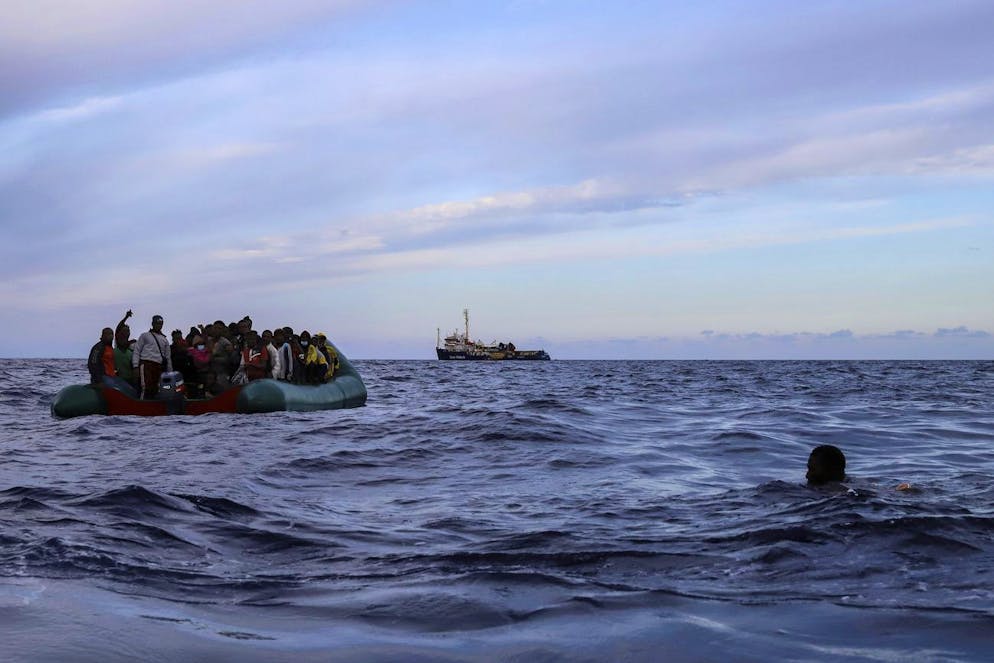 A migrant who was aboard a precarious rubber boat with others jumps to the water as they are rescued by a team of the Sea Watch-3, around 35 miles away from Libya, in Libyan SAR zone, Monday, Oct. 18, 2021. (AP Photo/Valeria Mongelli)