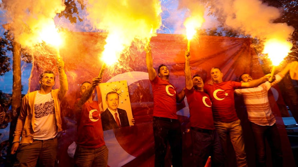 epa06837129 Supporters of Turkish President Erdogan hold a Turkish flag and light flares after closing voting for the Turkish presidential and parliamentary elections in Istanbul, Turkey, 24 June 2018. Some 56.3 million registered citizens voted in snap presidential and parliamentary elections to elect 600 lawmakers and the country's president, the first election since the Turkish people in a referendum in April 2017 voted to change the country's system from a parliamentary to a presidential republic. EPA/SRDJAN SUKI