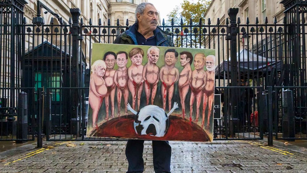 epa09552485 Political satire artist Kaya Mar with his latest climate painting ahead of COP26 showing a sinking world outside Downing Street in London, Britain, 29 October 2021.Protests are taking place in the capital ahead of climate change conference COP26 in Glasgow. EPA/VICKIE FLORES
