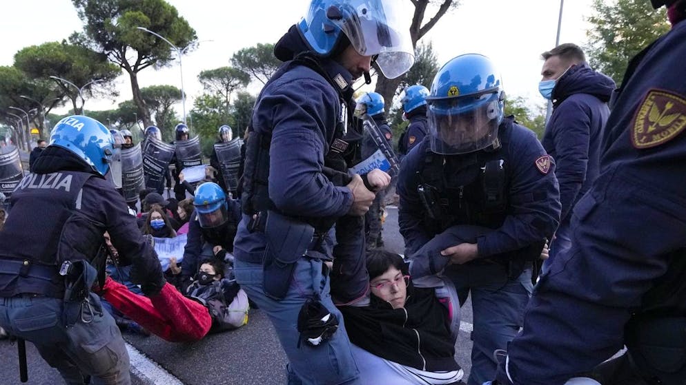 Italian Police remove climate activists trying to block traffic in front of the Italian Ministry of the Ecological Transition in Rome's via Cristoforo Colombo, one of the main road leading to La Nuvola (the cloud) convention center where the G20 summit is taking place, Saturday, Oct. 30, 2021. (AP Photo/Luca Bruno)