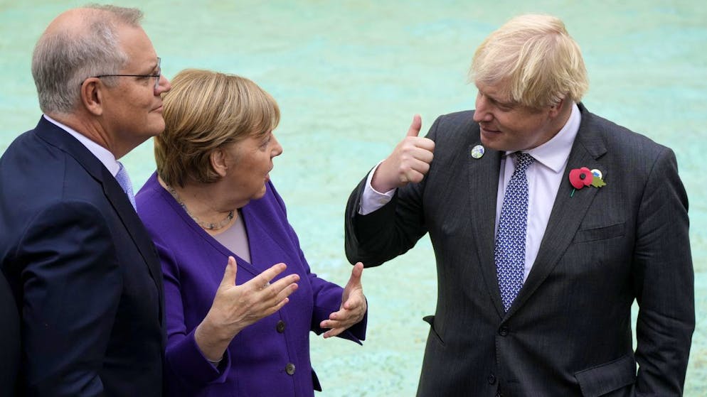 German Chancellor Angela Merkel, center, speaks with Australia's Prime Minister Scott Morrison, left, and British Prime Minister Boris Johnson in front of the Trevi Fountain during an event for the G20 summit in Rome, Sunday, Oct. 31, 2021. The two-day Group of 20 summit concludes on Sunday, the first in-person gathering of leaders of the world's biggest economies since the COVID-19 pandemic started. (AP Photo/Gregorio Borgia)