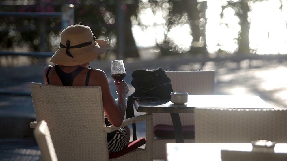 A woman sits in a terrace bar near the beach of Palma de Mallorca, Spain, Monday, June 15, 2020. Borders opened up across Europe on Monday after three months of coronavirus closures that began chaotically in March. But many restrictions persist, it's unclear how keen Europeans will be to travel this summer and the continent is still closed to Americans, Asians and other international tourists. (AP Photo/Joan Mateu)