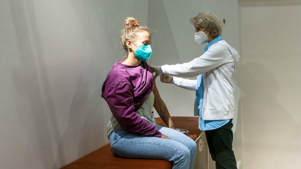 29.12.2020, Hamburg: Eine junge Frau erhält als Test-Impfling bei einem Probelauf des Hamburger Corona-Impfzentrums eine fingierte Impfung. Foto: Markus Scholz/dpa +++ dpa-Bildfunk +++ (KEYSTONE/DPA/Markus Scholz)