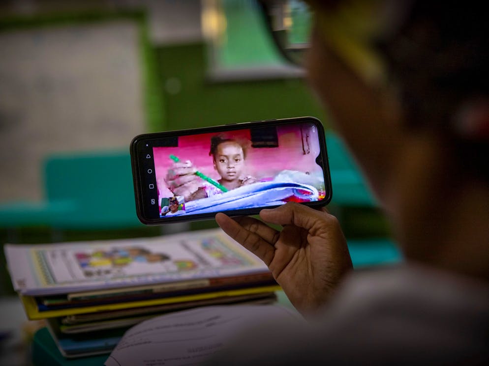Simões Filho. Quilombo community de Dandá. Municipal School.
Marizete Santana, teacher, giving online lessons to young girl at her home, over her phone.
Schools is open but face-to-face classes still not allowed. Most of the students have difficulties with internet access.