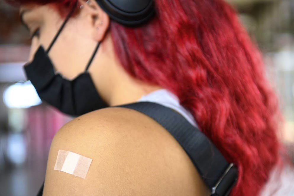 A student patient with a strip waits under observation after receiving a shot of the Moderna COVID-19 vaccine at the coronavirus vaccine facility of Unisante at the University of Lausanne, UNIL, during the coronavirus disease (COVID-19) outbreak, in Lausanne, Switzerland, Thursday, September 16, 2021. The Covid pass will be required from next Monday for students to attend classes. Many universities in Switzerland will introduce the Covid certificate. (KEYSTONE/Laurent Gillieron)