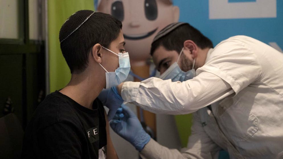 A 14-year-old Israeli receives a booster shot of the coronavirus vaccine at Clalit Health Service's center in the Cinema City complex in Jerusalem, Wednesday, Sept. 22, 2021. Israel is pressing ahead with its aggressive campaign of offering coronavirus boosters to almost anyone over 12 and says its approach was further vindicated by a U.S. decision to give the shots to older patients or those at higher risk. (AP Photo/Maya Alleruzzo)