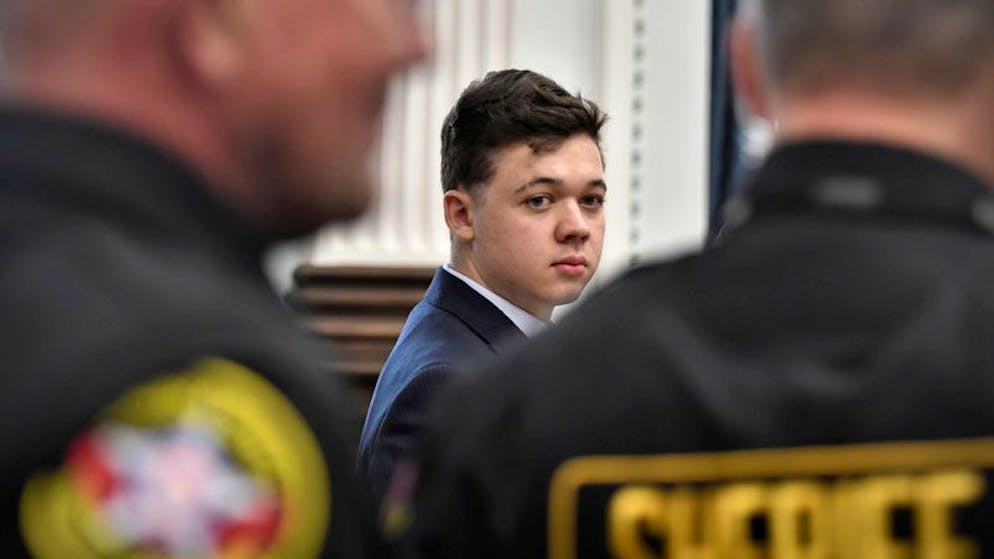 05.11.2021, USA, Kenosha: Der Angeklagte Kyle Rittenhouse (M) blickt nach hinten während Abgeordnete des Sheriffs den Saal betreten um ihn während einer Prozesspause im Gerichtsgebäude aus dem Saal zu begleiten. Rittenhouse wird vorgeworfen, im vergangenen Jahr bei einer Demonstration gegen Polizeibrutalität in zwei Menschen getötet und einen dritten verletzt zu haben. Foto: Sean Krajacic/Pool The Kenosha News/dpa +++ dpa-Bildfunk +++