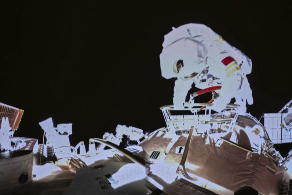In this image released by the Xinhua News Agency, a photo taken on a screen shows Chinese astronaut Wang Yaping conducts an activities outside the space station's Tianhe core module, at Beijing Aerospace Control Center on Sunday, Nov. 7, 2021. Wang Yaping has become the first Chinese woman to conduct a spacewalk as part of a six-month mission to the country's space station. Wang and fellow astronaut Zhai Zhigang left the station's Tianhe core module on Sunday evening Beijing time, spending more than six hours installing equipment and carrying out tests alongside the station's robotic service arm. (Guo Zhongzheng/Xinhua via AP)