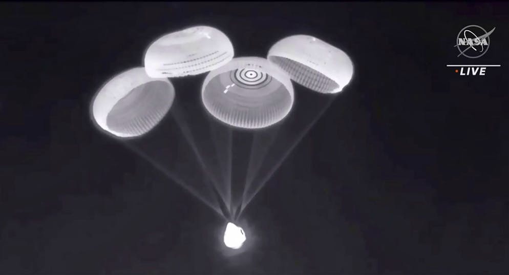Dans cette image tirée d'une vidéo de la NASA, des parachutes sont déployés à partir de la capsule SpaceX Dragon, transportant quatre astronautes, alors qu'elle descend avant de plonger dans le golfe du Mexique près de Pensacola, en Floride, le lundi 8 novembre 2021.