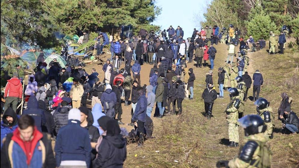 Migranti in piedi al confine tra Polonia e Bielorussia al valico di frontiera di Grodno.