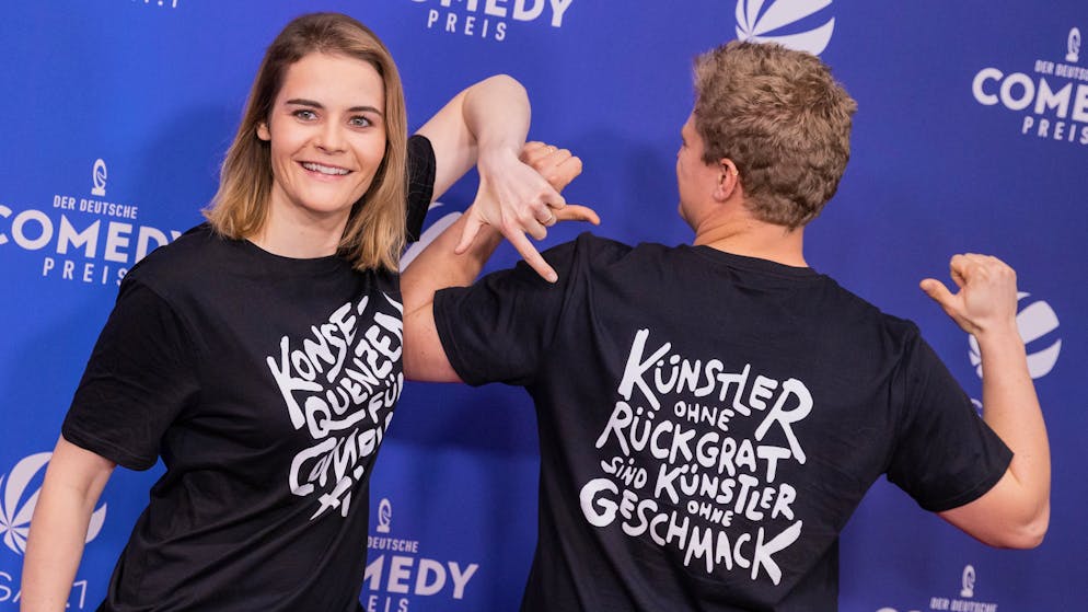 01.10.2021, Nordrhein-Westfalen, Köln: Hazel Brugger und ihr Mann Thomas Spitzer mit T-Shirt mit der Aufschrift «Konsequenzen für Comedian XY» kommen über den Roten Teppich zur Verleihung des «Deutschen Comedypreises». Die beliebtesten Comedy-Sendungen, Podcasts und Künstlerinnen und Künstler werden ausgezeichnet. Foto: Rolf Vennenbernd/dpa +++ dpa-Bildfunk +++ (KEYSTONE/DPA/Rolf Vennenbernd)