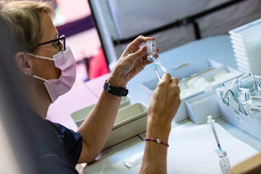 Eine Frau bereitet eine Spritze mit Impfstoff fuer eine Impfung in einer mobilen Impfstation vor, die im Rahmen der Sensibilisierungskampagne