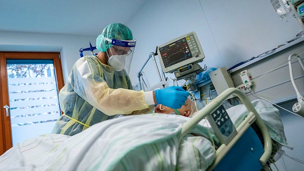 Ein Intensivpfleger betreut einen Corona-Patienten (Archiv)
