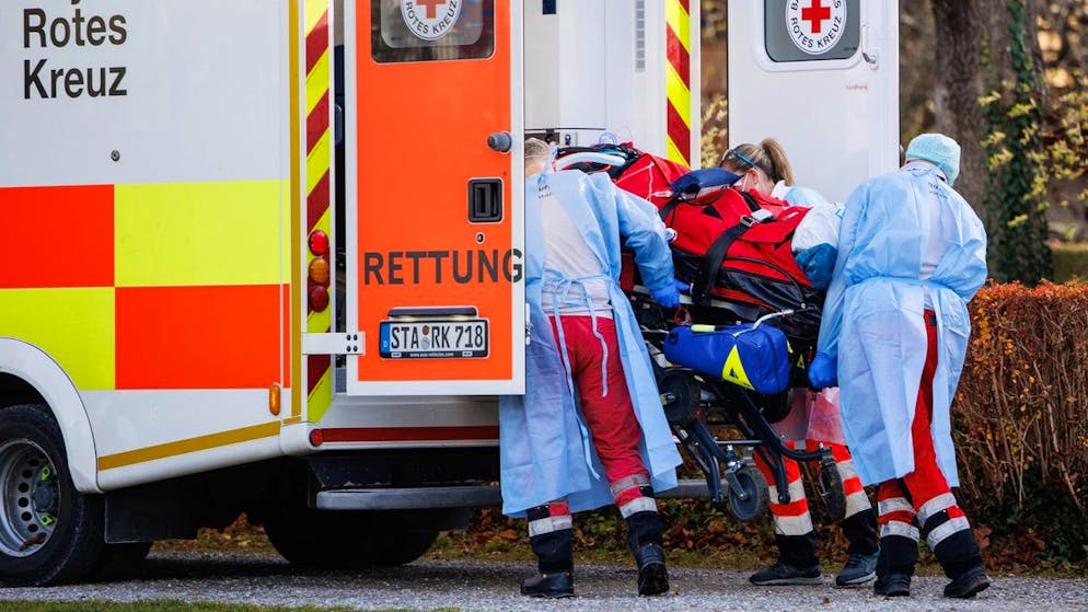 dpatopbilder - 19.11.2021, Bayern, Herrsching Am Ammersee: Rettungskräfte verladen einen Covid-19-Intensivpatienten aus einem Hubschrauber der Luftrettung auf einem Sportplatz in ein Fahrzeug vom Rettungsdienst. Der Covid-19-Intensivpatient wird aus dem Klinikum in Trostberg in eine Privatklinik in Herrsching am Ammersee verlegt. Foto: Matthias Balk/dpa +++ dpa-Bildfunk +++ (KEYSTONE/DPA/Matthias Balk)