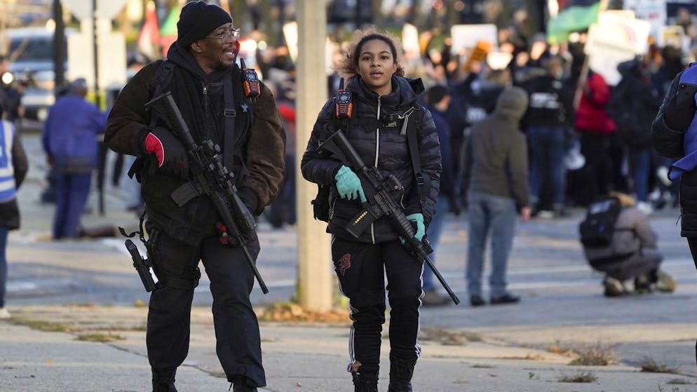 Erick Jordan and his daughter Jade, 16, walk with rifles with protesters marching Sunday, Nov. 21, 2021 in Kenosha, Wis. Kyle Rittenhouse was acquitted of all charges after pleading self-defense in the deadly Kenosha shootings that became a flashpoint in the nation's debate over guns, vigilantism and racial injustice. (AP Photo/Paul Sancya)