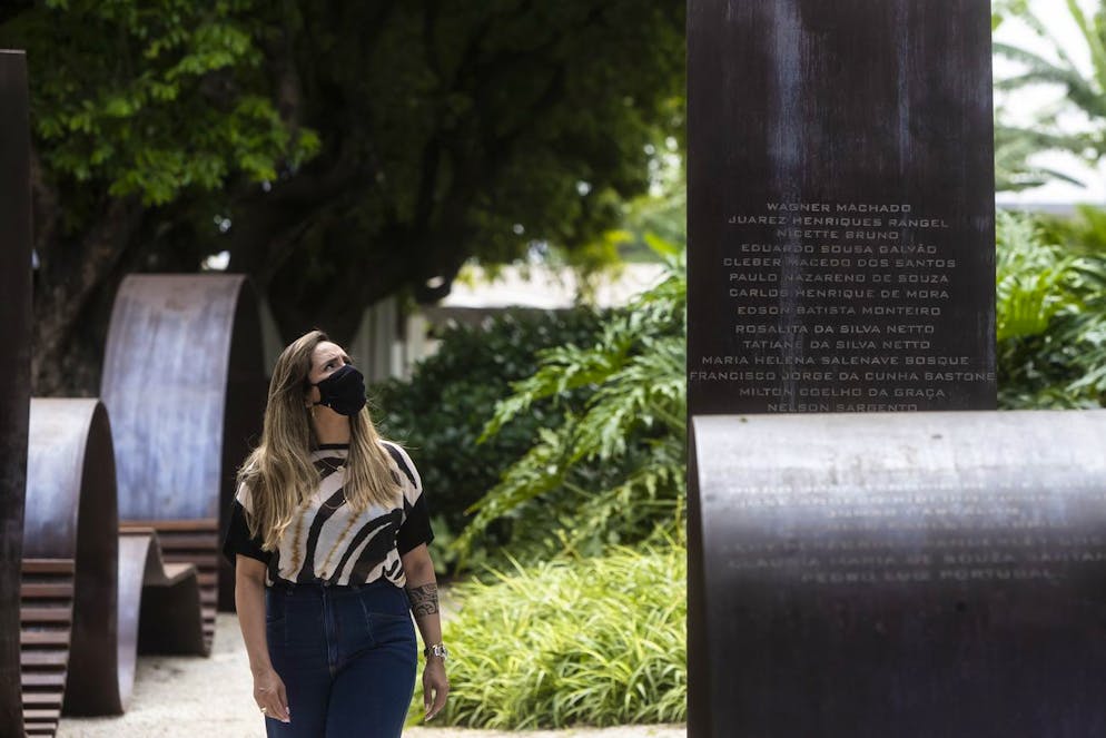 FILE - Erika Machado visits a memorial for COVID-19 victims at Penitencia cemetery, Oct. 27, 2021, in Rio de Janeiro, Brazil. Her father's name Wagner Machado is engraved on the memorial. (AP Photo/Bruna Prado, File)