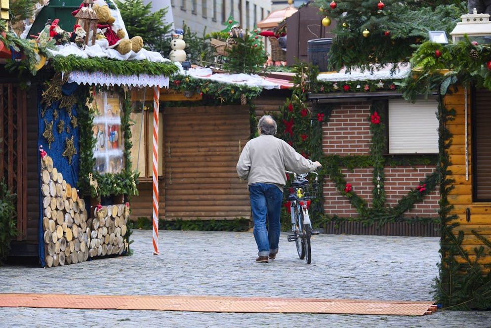 A man walks through a closed Christmas Market in Berlin, Germany, Sunday, Nov. 21, 2021. Because of the high number of infections with the coronavirus Christmas markets in the German federal state Saxony not allowed to open. (Robert Michael/dpa via AP)