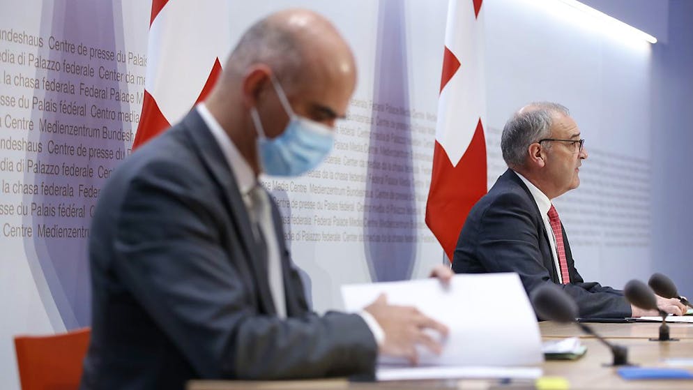 Il presidente della Confederazione, Guy Parmelin, sullo sfondo e, in primo piano, il ministro della sanità, Alain Berset, durante la presentazione odierna della nuove misure restrittive